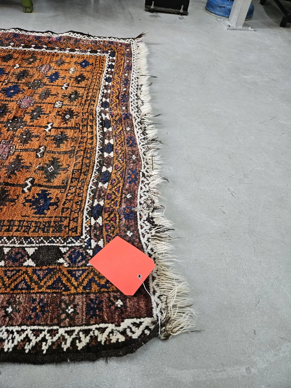 Hand-tied fringe being rebuilt on a wool rug at the bench in Aventura