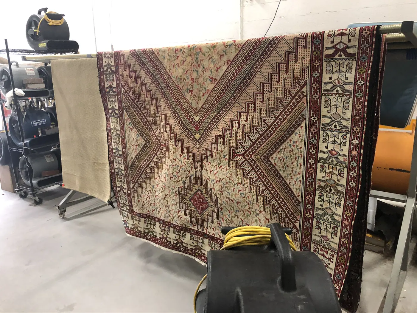 Tribal rug hung vertically to show its full pattern after cleaning